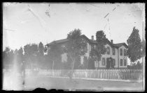 Two-story institutional building, with horse and carriage outside