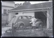 Man posing with automobile in driveway