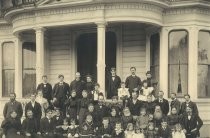 Group portrait in front of Victorian house