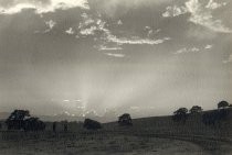 Two walkers on trail with rays of light