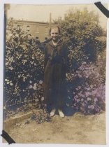 Young woman in school uniform posing in front of garden