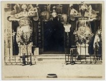 Tall Chinese figures and lanterns outside Ng Shing Gung