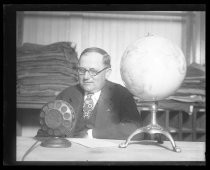 Man sitting at desk with globe and broadcast microphone