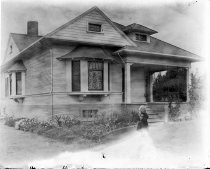 Young girl outside Victorian home, c. 1912