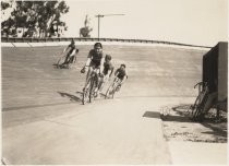 Four bicycle riders racing in velodrome