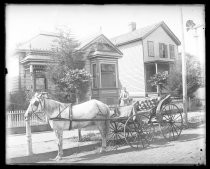 Horse-drawn carriage parked in front of Victorian bungalow