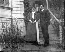 Man and woman in front of white house, c. 1912