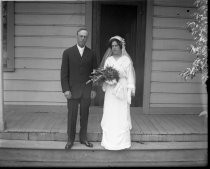 Bride and groom on steps of house, c. 1912