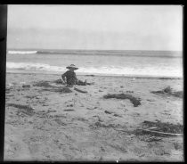 Child on beach, with shovel and pail, c. 1900