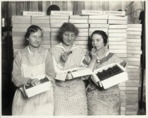 Three women with boxes of prunes