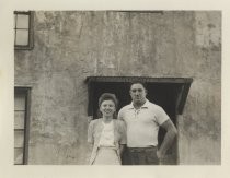 Ed and Ruby Levin posing outside concrete building