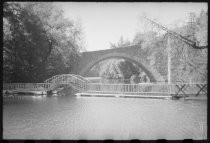 Stone arched bridge over river, with walkway in front