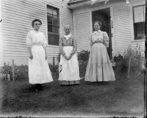 Three women in front of white farmhouse, c. 1912