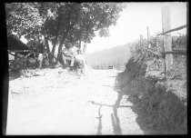 People sitting alongside dirt road in country