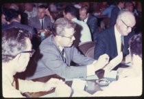 Men seated around table at conference