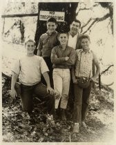 Frank Muller posing with kids underneath a tree