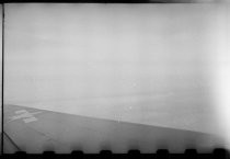 View over plane wing towards Alaska coastline