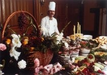 Lou's Village chef with food display