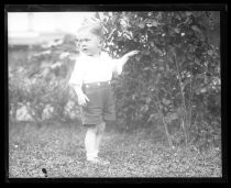 Toddler in shirt and shorts posing in yard