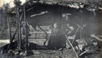 Unidentified woman seated in door of cabin