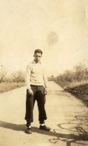 Man by side of road, with bicycle shadow