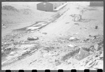 Hoses snaking along beach towards wreckage