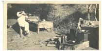 Man shooting rifle at outdoor camp