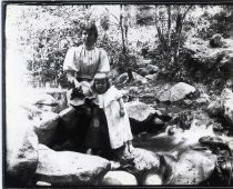 Mother and daughter on rocks in a stream