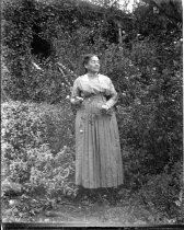 Woman standing in bushes, c. 1912