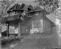 Large, wood-shingled home with stone columns, c. 1912