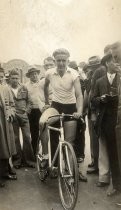 Bike racer surrounded by crowd at start