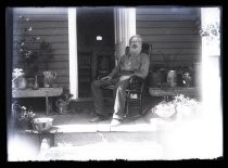 Bearded man sitting in rocking chair on porch