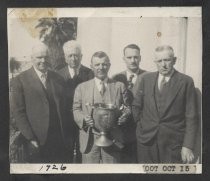 Five men and trophy cup