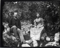 Man and woman on banks of a stream