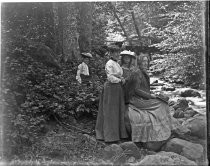 Four women outdoors next to stream, c. 1912