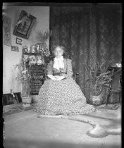 Older woman seated in chair with book