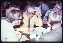 Men seated around table at conference