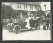 Group of men amd women in and around Winton automobile