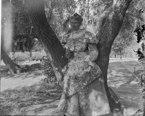 Woman seated in tree, c. 1912