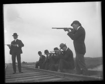 Six men on railroad tracks, with guns