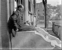 Man feeding squirrel on stoop, c. 1912