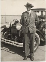 Roy Francis in suit, in front of Buick automobile for Howard Automobile Co