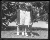 Twins in yard wearing brocade jacket