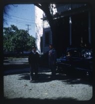 Three men with Buick in front of white house