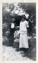 Two women and a young boy in nautical-themed suit