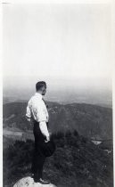 Man atop high rock, looking down at valley