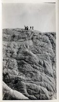 Group waving from top of rock face