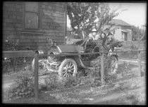 Family in Mitchell auto outside house, c. 1910