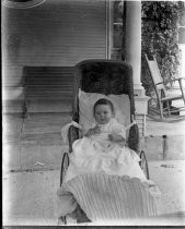 Infant in baby carriage outdoors, c. 1912