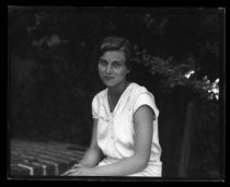 Outdoor portrait of young woman in white, short-sleeved dress